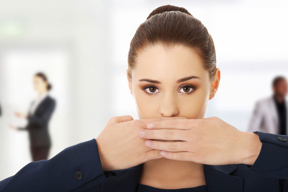 Portrait-of-young-businesswoman-covering-with-hand-her-mouth_ml